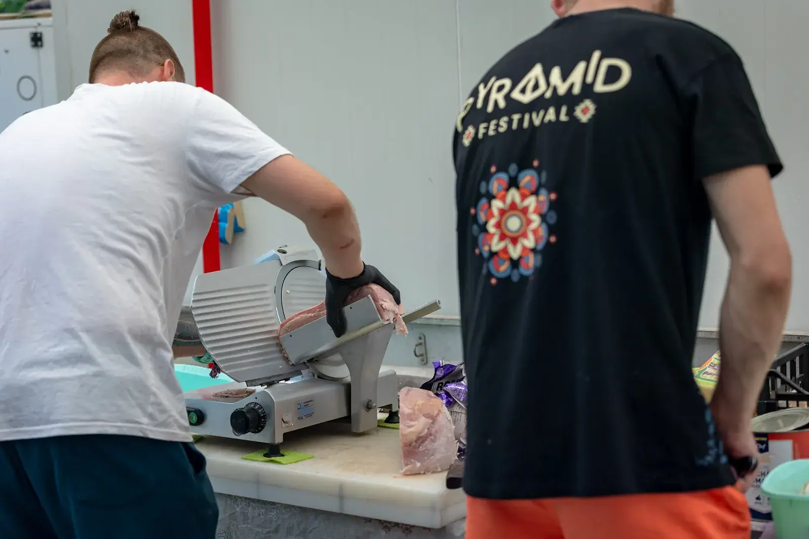 A volunteer in a Pyramid shirt preparing food