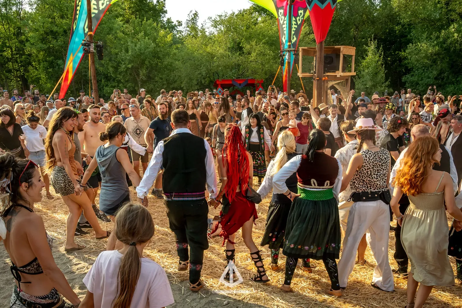 Masa ljudi igra kolo na livadi festivala