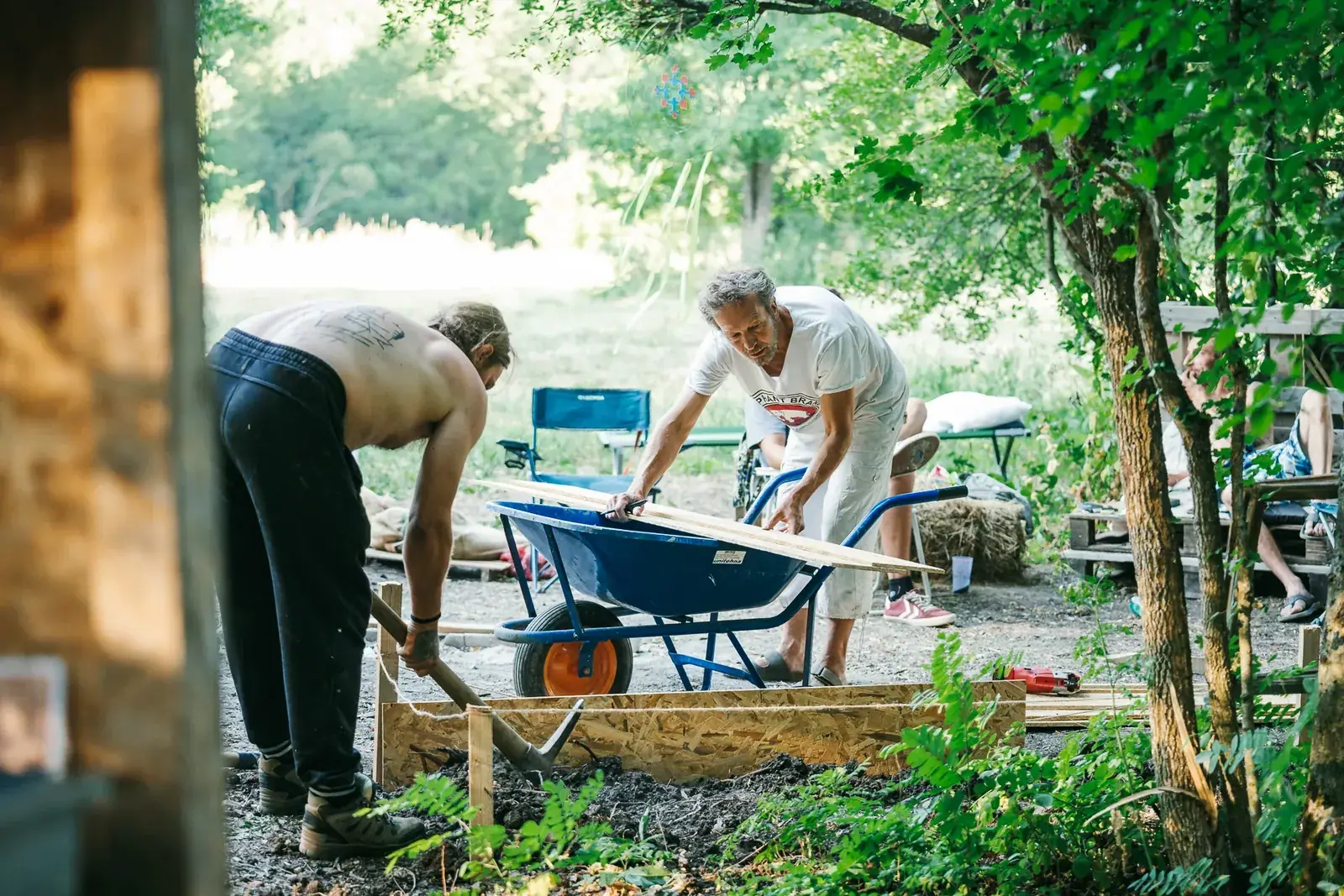 Two people working in the garden with a wheelbarrow