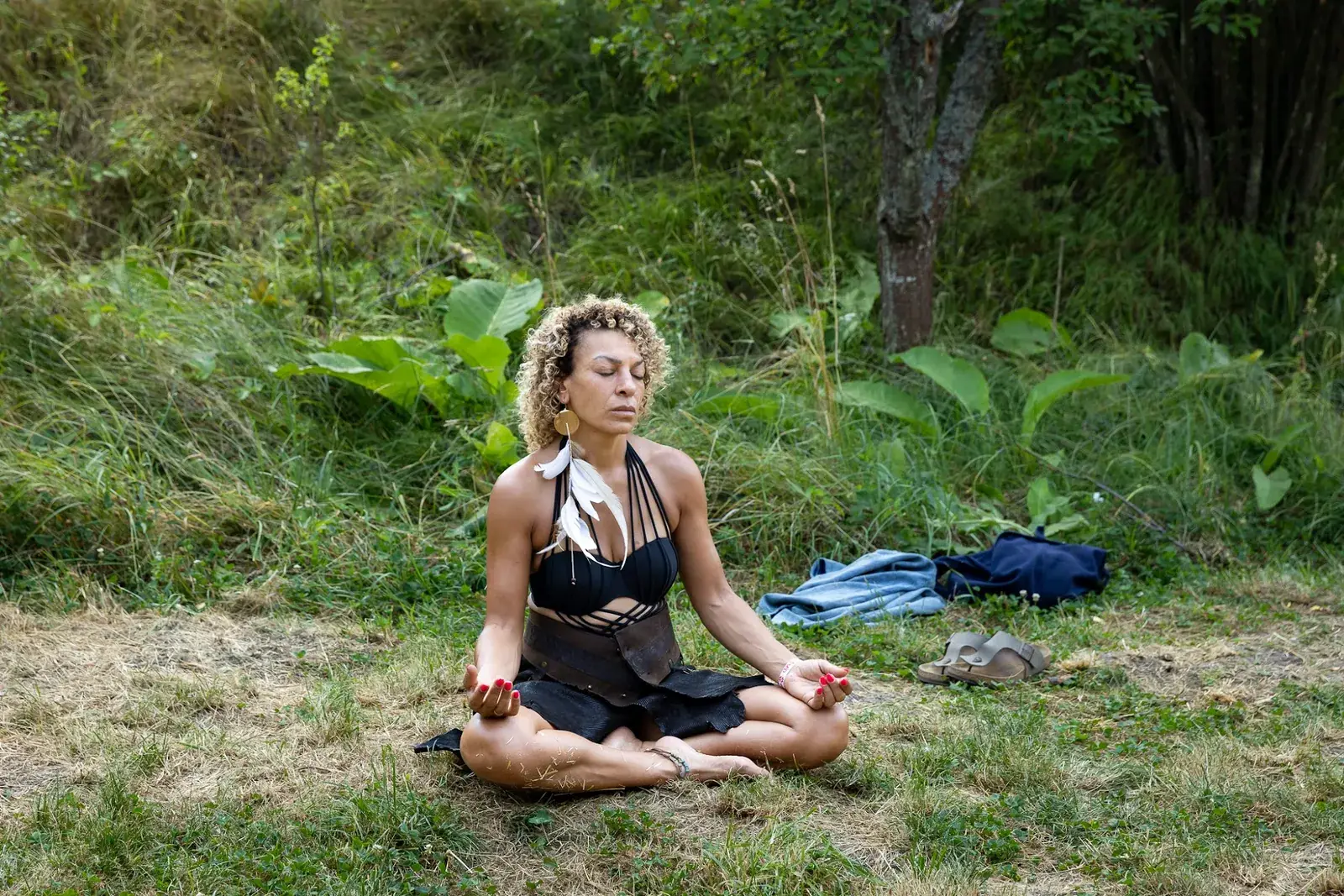 A woman meditating alone on the grass