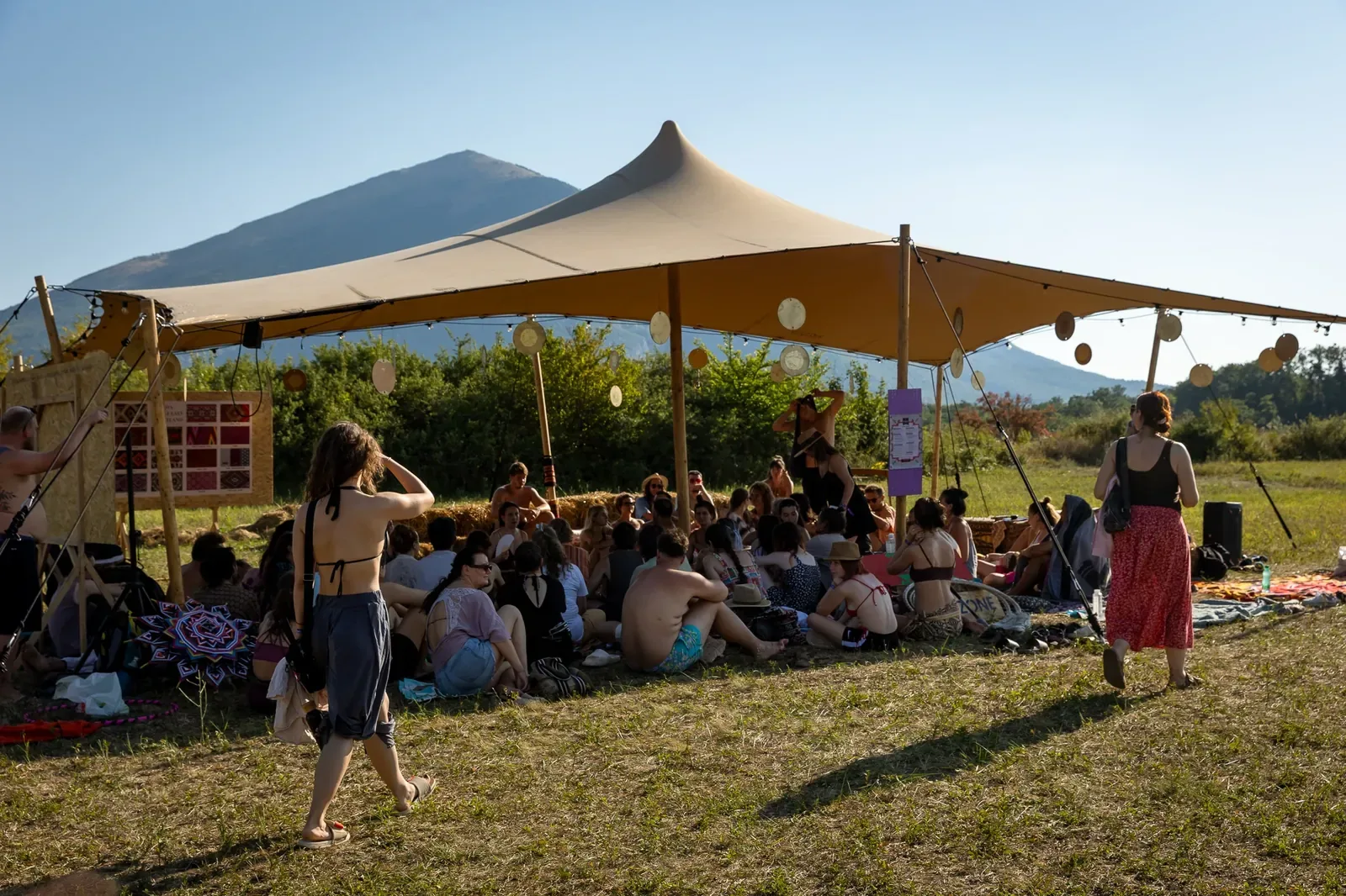 A workshop under a tent on the meadow with the pyramid peak of Rtanj behind